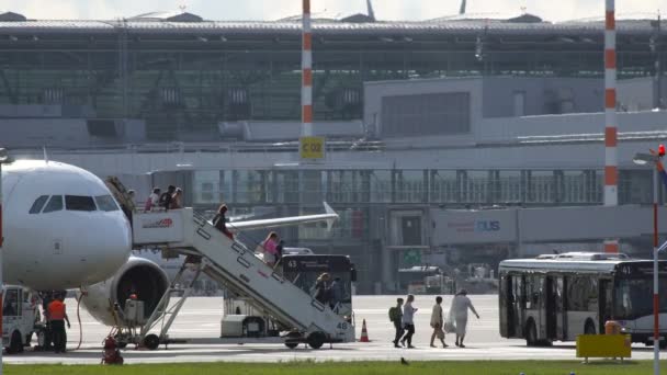 Pasajeros bajan la escalera desde el avión — Vídeos de Stock