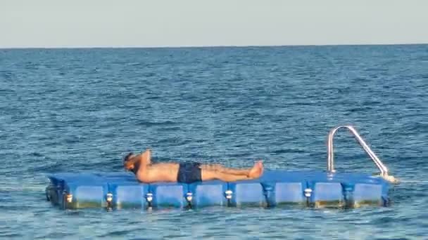 Homem deitado numa jangada no oceano — Vídeo de Stock