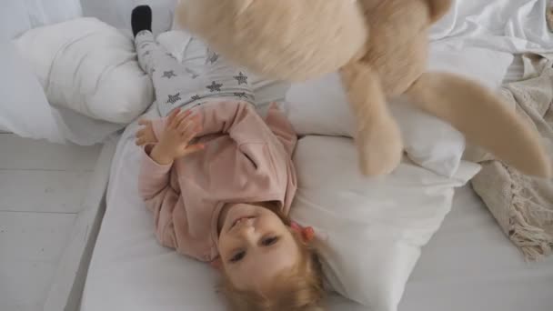 Маленькая симпатичная девочка играет с кроликом — стоковое видео