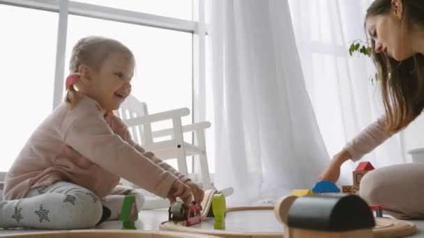 Маленькая милая девочка играет с деревянными игрушками — стоковое видео