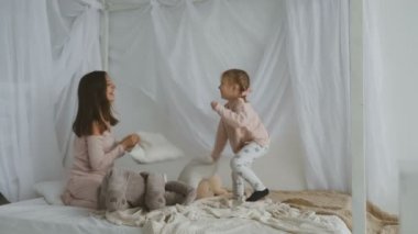 Anne ve küçük kızı yastık ile oynamak