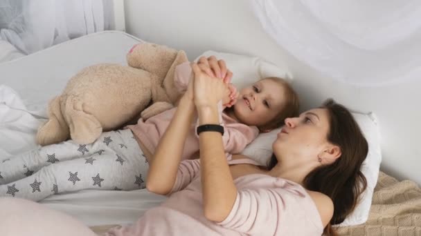 Madre y su niña jugando en la cama — Vídeos de Stock