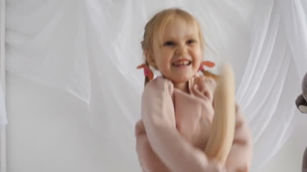 Kleines Mädchen spielt mit Plüschkaninchen — Stockvideo