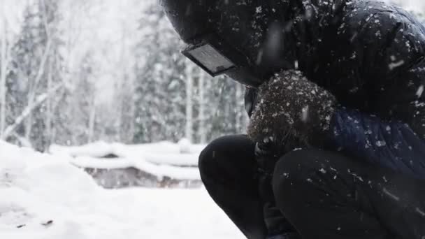 Människan svetsar delar utomhus på vintern. — Stockvideo