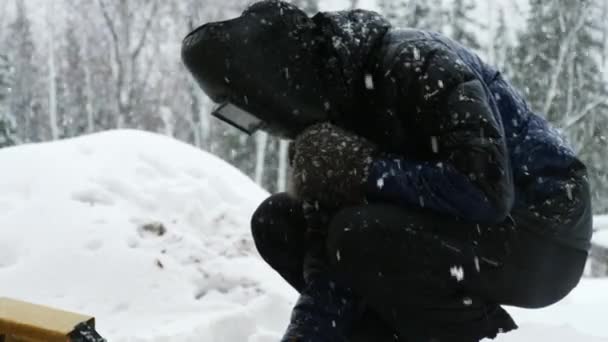 Чоловік зварює металеві деталі на відкритому повітрі взимку . — стокове відео