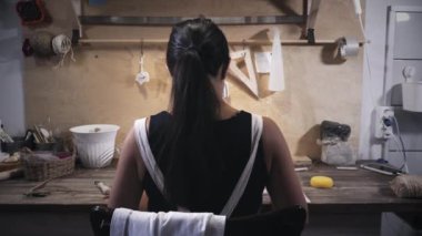 Kadın çömlek atölyesinde çalışıyor.