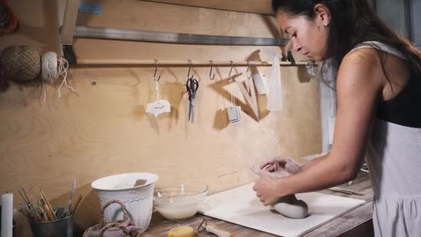 Азиатка замесила глину в его студии — стоковое видео