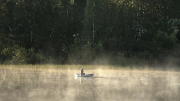 Man in an inflatable boat on the lake — Αρχείο Βίντεο