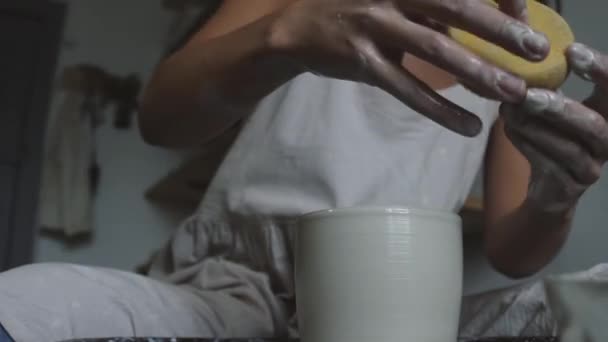 Kobieta garncarz formowania mokrej gliny garnek z mokrej gąbki — Wideo stockowe