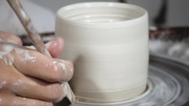 Çömlek çarkında kil kabı şekillendiriyorum.