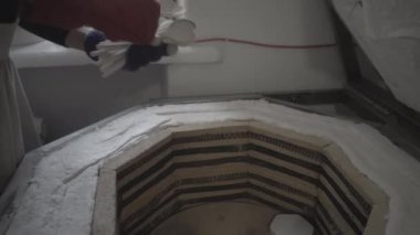 Potter çömlek fırınından kil kaşık çıkarıyor.