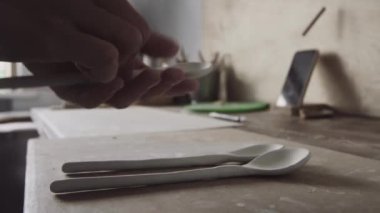 Potter çömlek fırınına kil kaşık koyar.