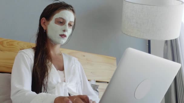 Woman with facial mask uses laptop — 비디오