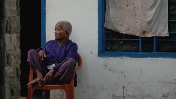 Vietnamesiska gubben sitter på en stol — Stockvideo