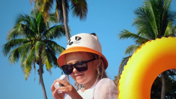 Маленька дівчинка відео блогер знімається на пляжі — стокове відео