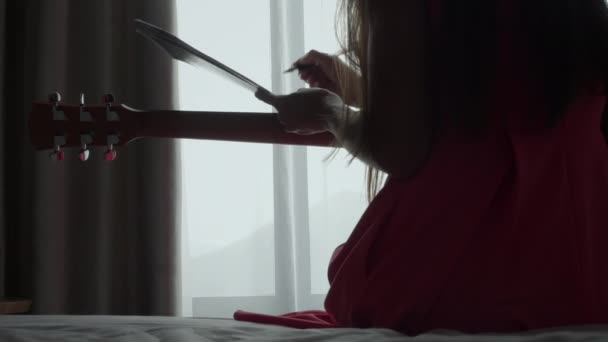 Silhouette della ragazza che scrive nuova canzone con chitarra — Video Stock