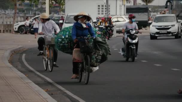 Vietnamese vrouw rijden op de fiets met een zak van aluminium blikjes — Stockvideo