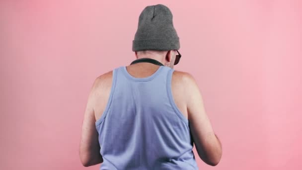 Filmaufnahmen eines alten Mannes in Tank-Top und Hut mit Popcorn. — Stockvideo