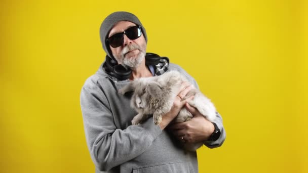 Vieil homme hipster avec un lapin sur les mains . — Video