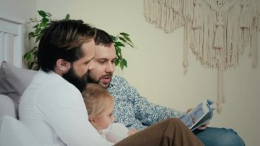 Homosexual Male Couple lying with daughter in bedroom