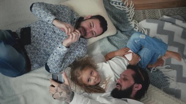 Male Couple Taking Selfies With Daughter On The Floor — Wideo stockowe