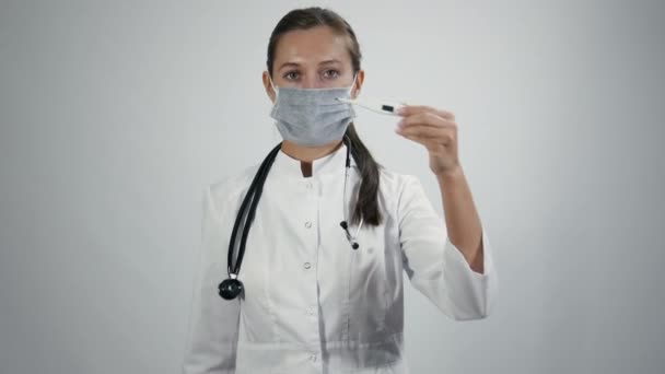 Termometresi olan tıbbi maskeli bir doktor. — Stok video