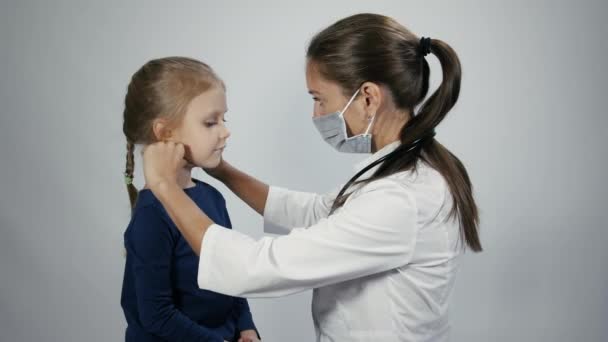 El doctor está palpando ganglio linfático en el cuello de la niña — Vídeo de stock