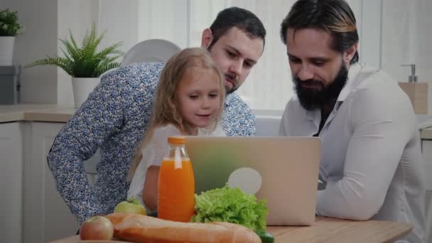 Två män med liten flicka tittar på laptop — Stockvideo