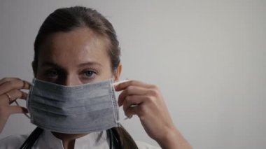 Doktor yüzüne tıbbi maske taktı.