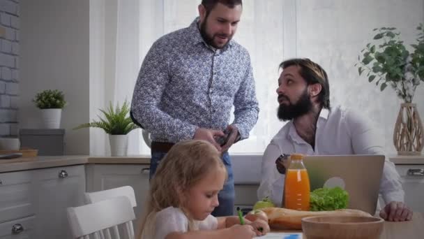 Pareja masculina usando portátil en la cocina — Vídeo de stock