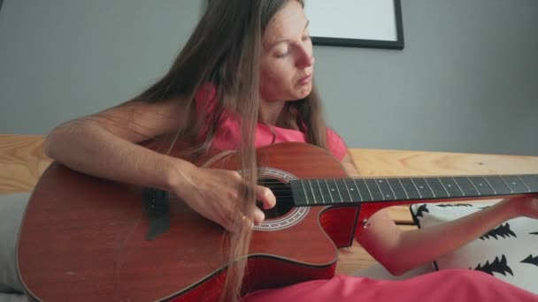 Mujer tocando la guitarra acústica en casa — Vídeos de Stock