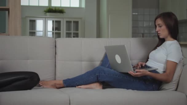 Meninas relaxadas no sofá usando gadgets — Vídeo de Stock