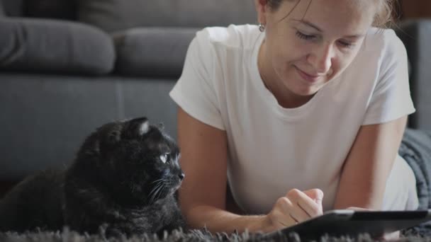 Kobieta używać tabletki w domu ze swoim zwierzakiem — Wideo stockowe