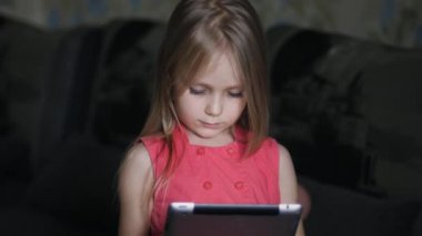 Evde dijital tablet kullanan küçük kız