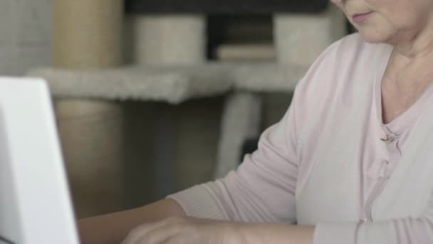 Зріла жінка працює з ноутбуком вдома — стокове відео