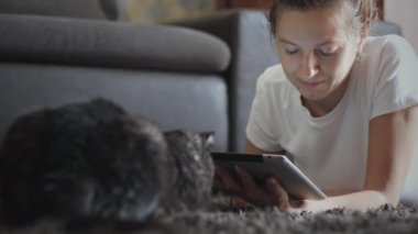 Evcil hayvanıyla tablet bilgisayar kullanan bir kadın.
