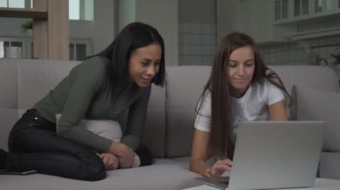 Evde Dizüstü bilgisayara bakan sohbet eden kızlar.