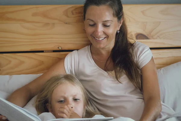 Fiatal Vidám Anya Fekszik Kislányával Ágyban Könyvet Olvas Tündérmeséket Olvasok — Stock Fotó