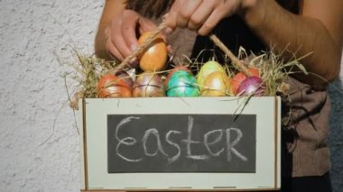 Kadın bir kutuya renkli paskalya yumurtası koymuş.