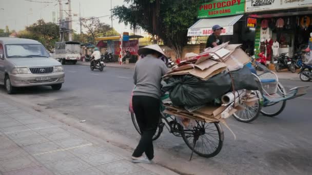 Asiatisk kvinna parkera en cykel med en massa skräp — Stockvideo