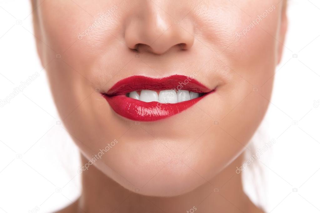 Sensuous woman biting red lips.