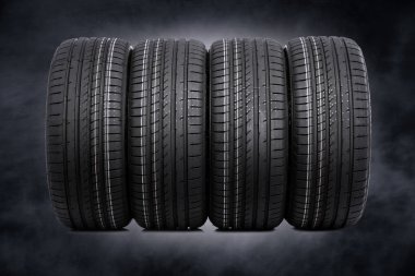 Karanlık bir arka plan üzerinde araba lastikleri.