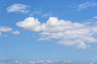 Beyaz bulutların üstünde mavi açık gökyüzü.