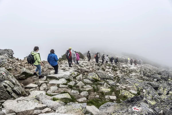 Grupo de excursionistas que descienden sobre una montaña . — Foto de Stock