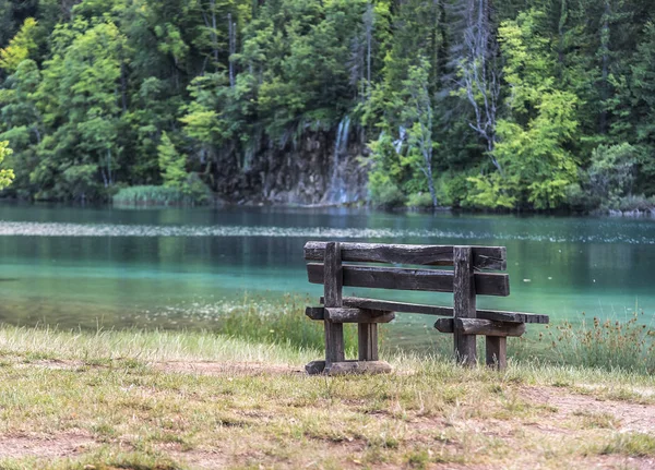 Empty bench on the waterfront with an amazing view of a lake. — Stock Photo, Image