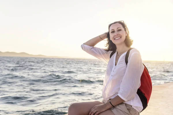 Ung kvinna på stranden vid solnedgången. — Stockfoto