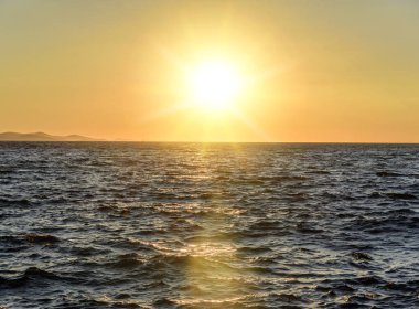 Denizin üzerinde gün batımı.