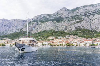 Bağlantı noktası Makarska, Hırvatistan ile neşeli turistler zevk tekne girer.