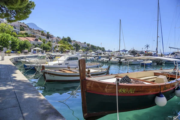 Visserij en plezier boten op de pier in het resort stad van Brela in Kroatië. — Stockfoto