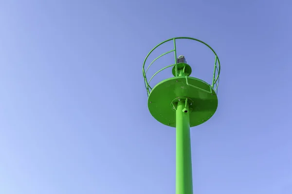 A small green lighthouse on the waterfront. — Stock Photo, Image